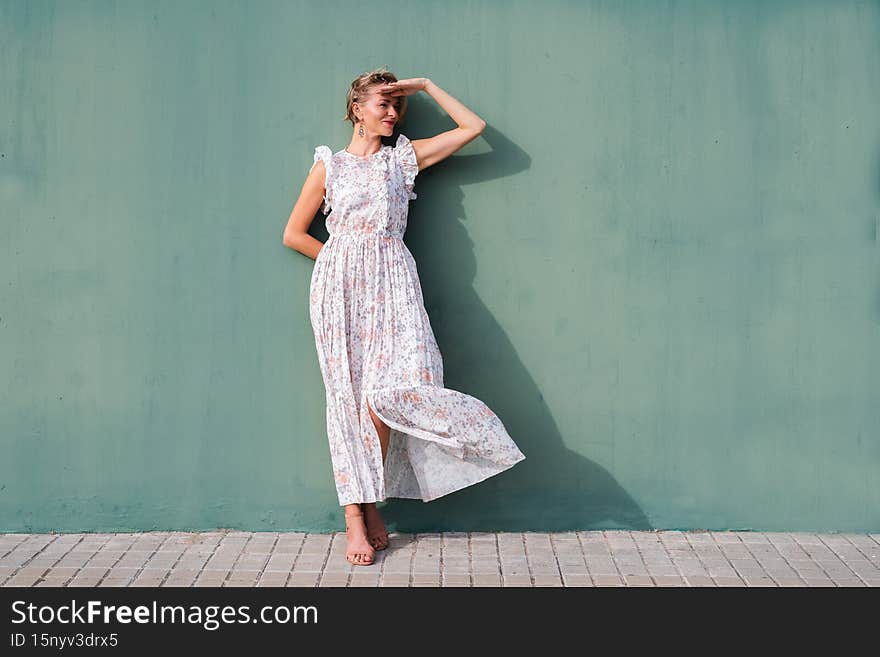 horizontal portrait of a beautiful blonde woman protecting her eyes with hand on a sunny day