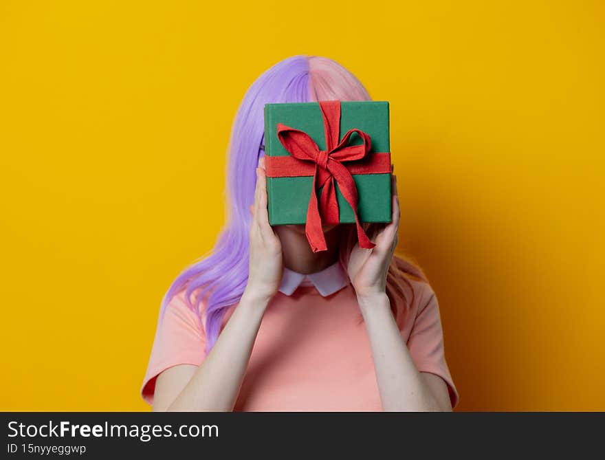 Girl with purple hair and pink dress hold gift box
