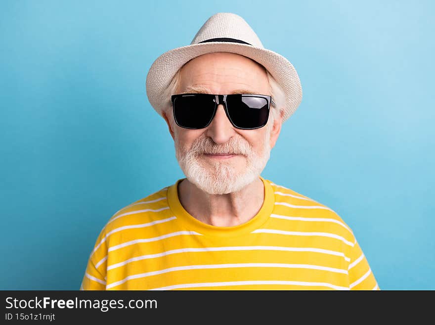 Close-up portrait of attractive cool man wearing black sun specs isolated over bright blue color background.