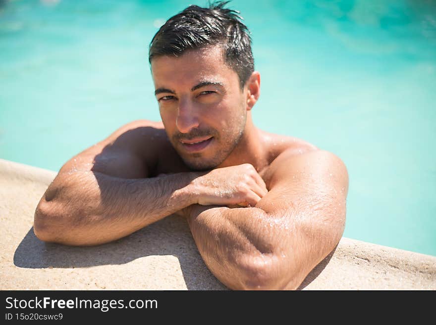 Handsome young man swimming in pool