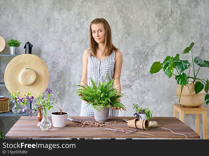 Woman transplanting a fern, a houseplant. Concept of home garden. Flower and garden shop.