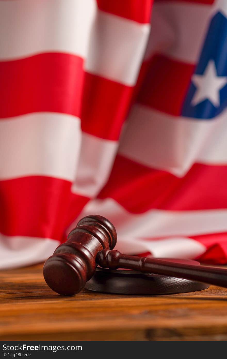 Wooden judge gavel and soundboard on american flag background