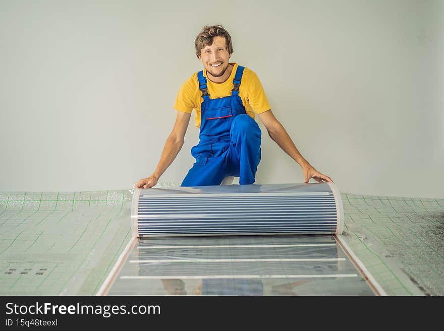 Master installs film warm floor in the room. Floor heating installation.