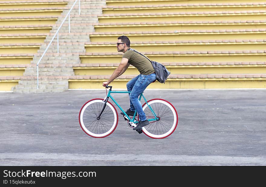 Smiling young man riding a bike on the city street. Smiling young man riding a bike on the city street
