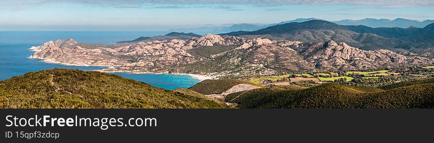 Panoramic view over Ostriconi beach and the turquoise Mediterranean sea in the Balagne region of Corsica with the Desert des Agriates in the distance. Panoramic view over Ostriconi beach and the turquoise Mediterranean sea in the Balagne region of Corsica with the Desert des Agriates in the distance