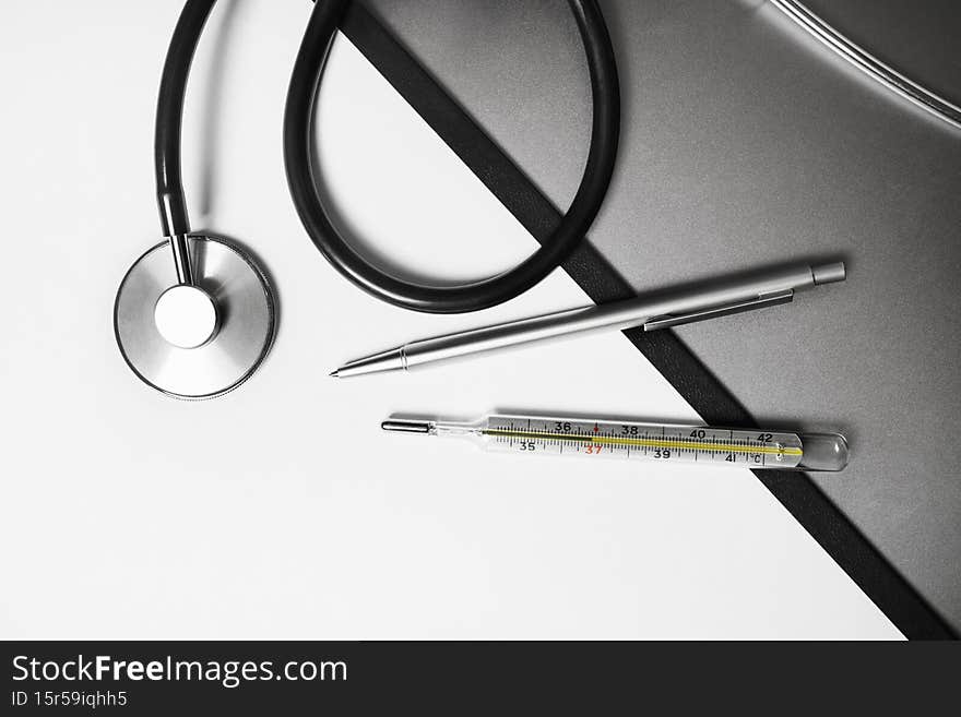 Medical stethoscope, thermometer and pen. Flat lay. Medical stethoscope, thermometer and pen. Flat lay