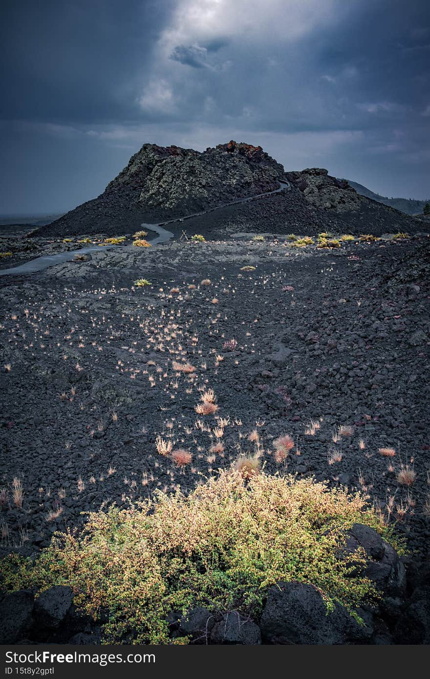 View of the spray cone trail on the horizon, lava hills, volcanic landscape at the Craters of the Moon National Monument & Preserve, Idaho, USA