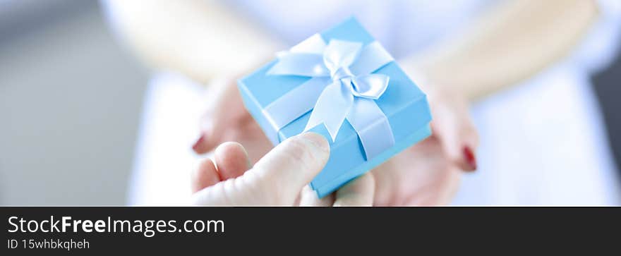 Man hand passes gift box to woman. Surprise for woman concept
