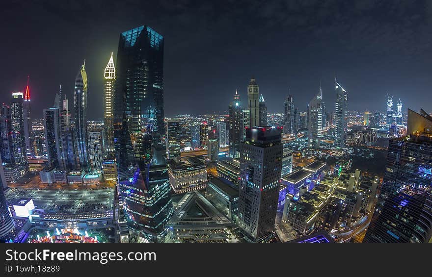 Panorama of futuristic skyscrapers in financial district business center in Dubai on Sheikh Zayed road night timelapse. Aerial view from above with illuminated towers. Panorama of futuristic skyscrapers in financial district business center in Dubai on Sheikh Zayed road night timelapse. Aerial view from above with illuminated towers
