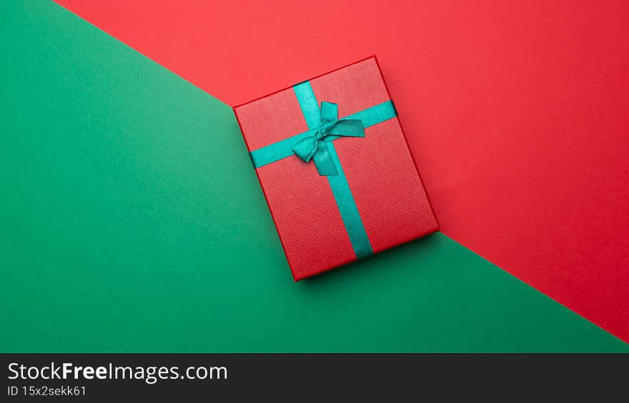 Celebratory background gift box on red and green background. Festive background for your design. Happy new year. Holiday concept. Celebratory background gift box on red and green background. Festive background for your design. Happy new year. Holiday concept