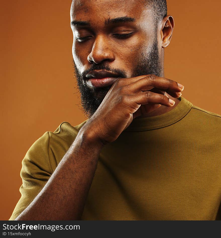 young pretty african american man posing cheerful on brown background, lifestyle people concept close up