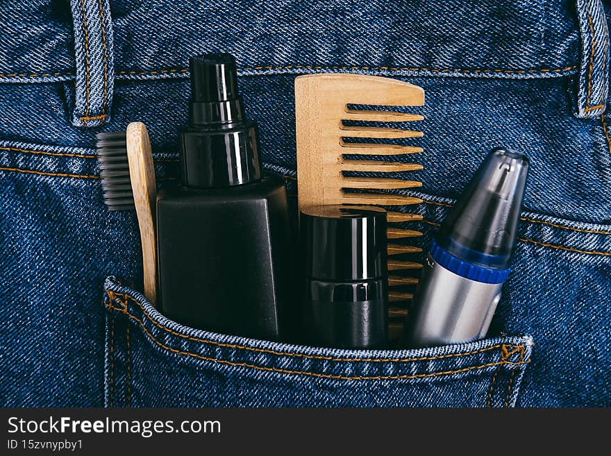 Men self care beauty kit, male beauty care cosmetic products and devices in blue jeans denim pocket. Man self care set with skin and hair care products