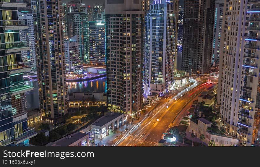 Aerial view on Dubai Marina skyscrapers and the most luxury yacht in harbor night timelapse, Dubai, United Arab Emirates