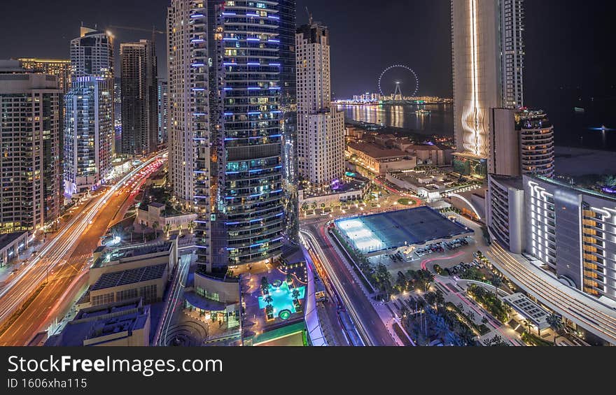 Panoramic view of the Dubai Marina and JBR area and the famous Ferris Wheel aerial night timelapse