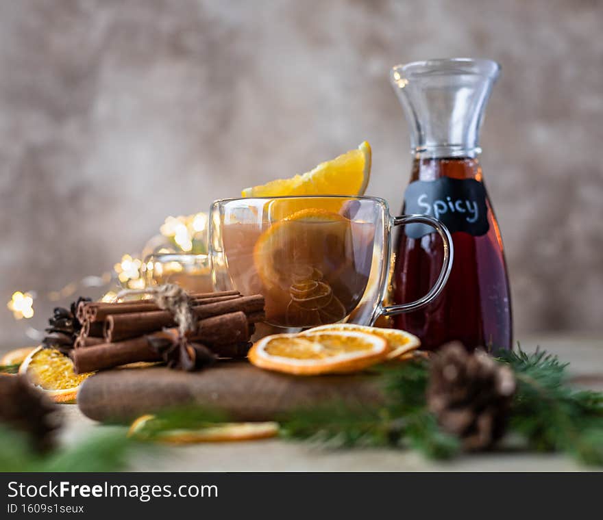 Hot tea or punch with orange and spices in a glass cup. Hot spicy beverage. Seasonal mulled drink