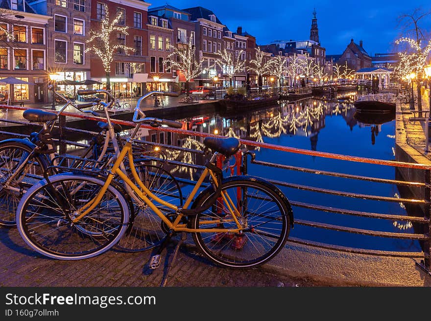 Beautiful old houses and illumination on the Leiden city embankment at sunset.