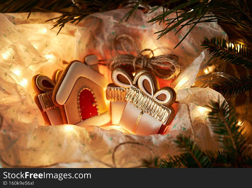 Christmas gingerbread cookies in a gift box with garland lights. Winter holidays celebration.