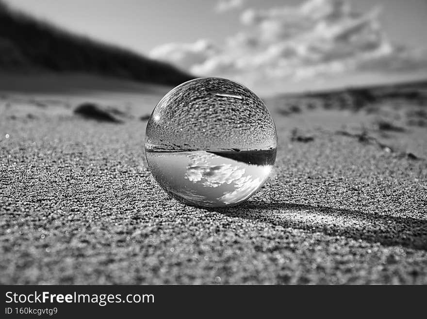 glass globe on the beach of the baltic sea. Black and white photograph