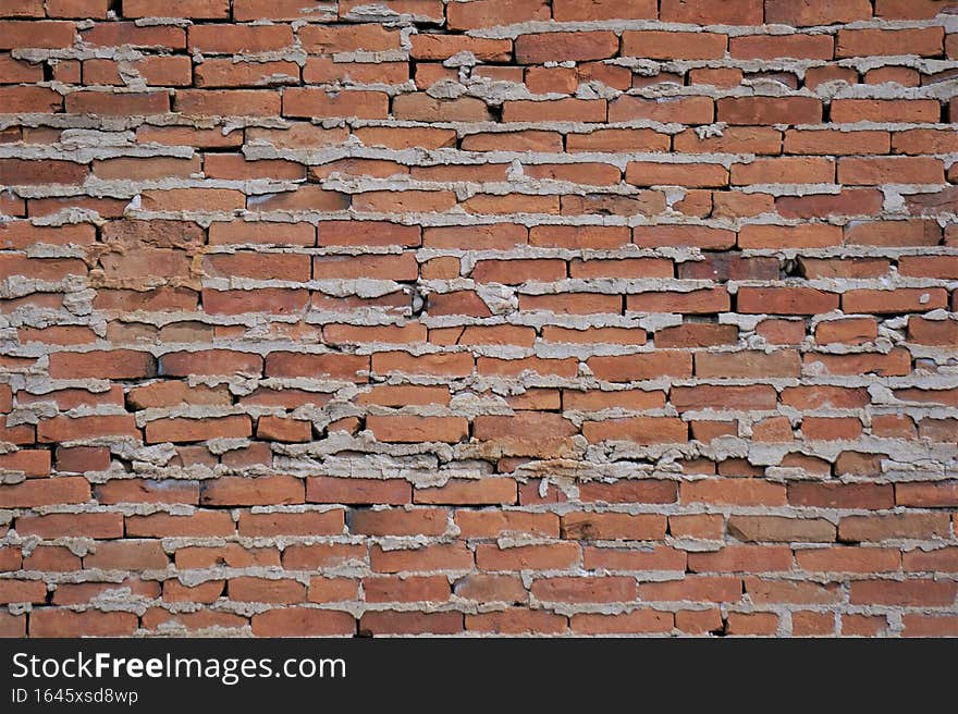 Do it yourself project composed of red rectangular clay brick blocks rest atop one another.  Sandwiched between each layer of horizontal rows is gray material designed to hold barricade together. Do it yourself project composed of red rectangular clay brick blocks rest atop one another.  Sandwiched between each layer of horizontal rows is gray material designed to hold barricade together.