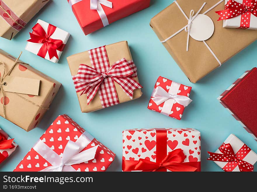 Top view photo of saint valentine`s day decorations presents different gift boxes with bows on isolated pastel blue background.