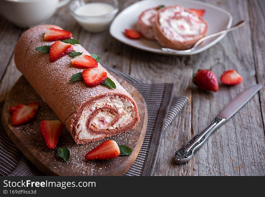 Delicious strawberry roll cake with white cream, homemade baked dessert