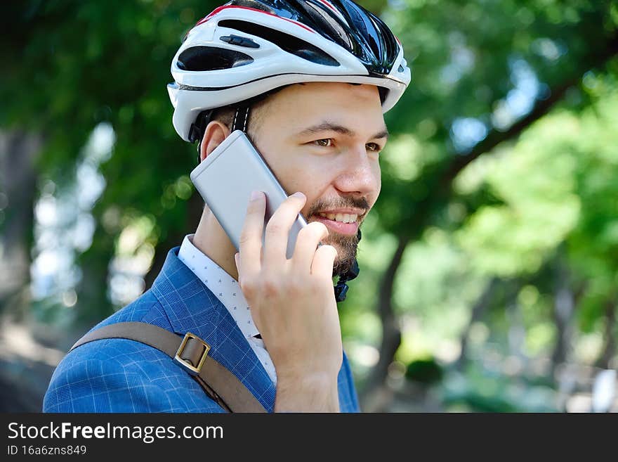 Bearded businessman in helmet talking on mobile phone