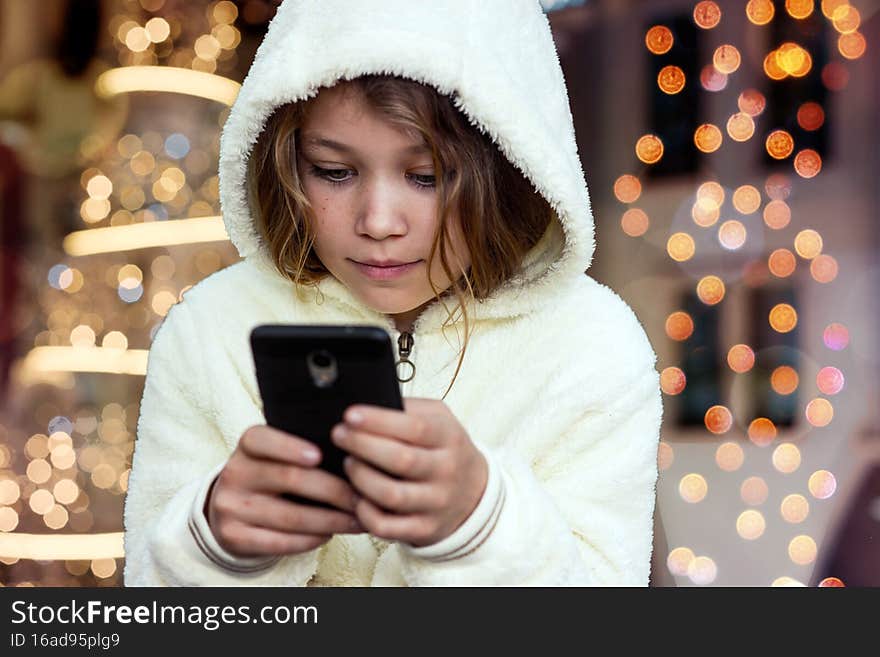 portrait of a young girl sending wishes with her smartphone. portrait of a young girl sending wishes with her smartphone