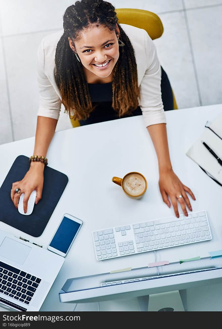 Onwards and upwards. High angle portrait of an attractive young businesswoman working at her desk in the office.