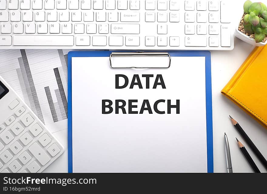 DATA BREACH written on the paper with keyboard, chart, calculator and notebook