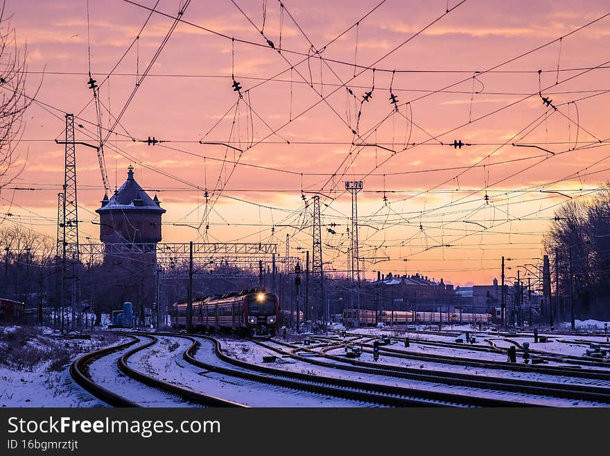 The passenger train travels on the tracks on a cold winter morning in the city. Selective focus. High quality photo