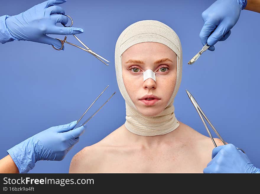 Doctors with different instruments and young woman on blue studio background.