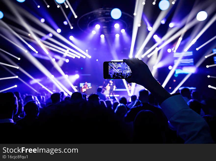 People at the concert. Using a smartphone.