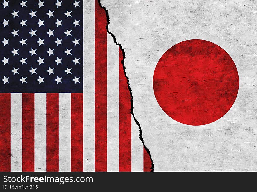 USA and Japan painted flags on a wall with a crack. United States of America and Japan relation