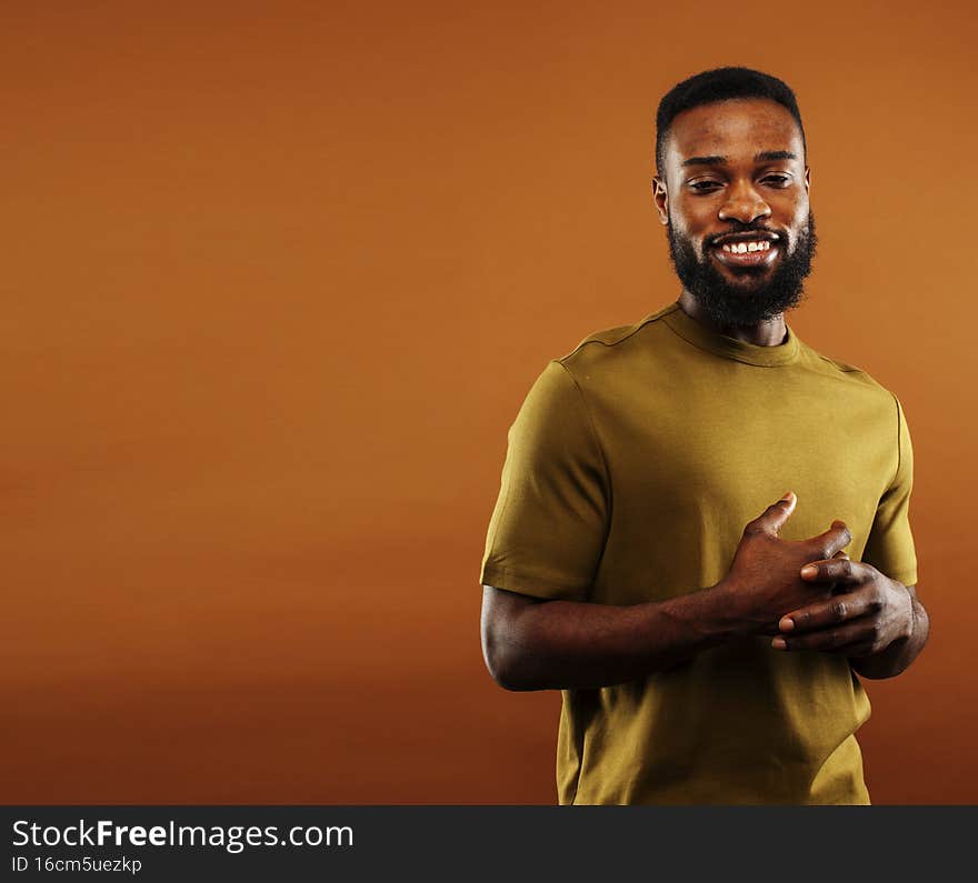young pretty african american man posing cheerful on brown background, lifestyle people concept close up