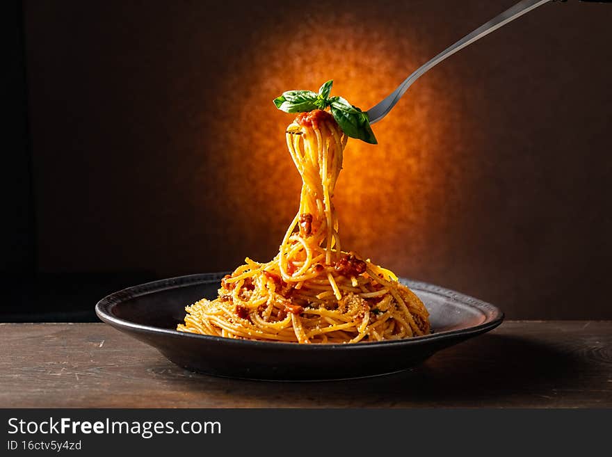 Spaghetti pasta bolognese in black plate.
Italian food image.