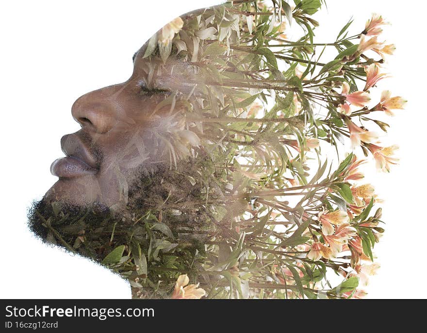 A profile portrait of a man combined with an image of flowers in a double exposure technique. A profile portrait of a man combined with an image of flowers in a double exposure technique.