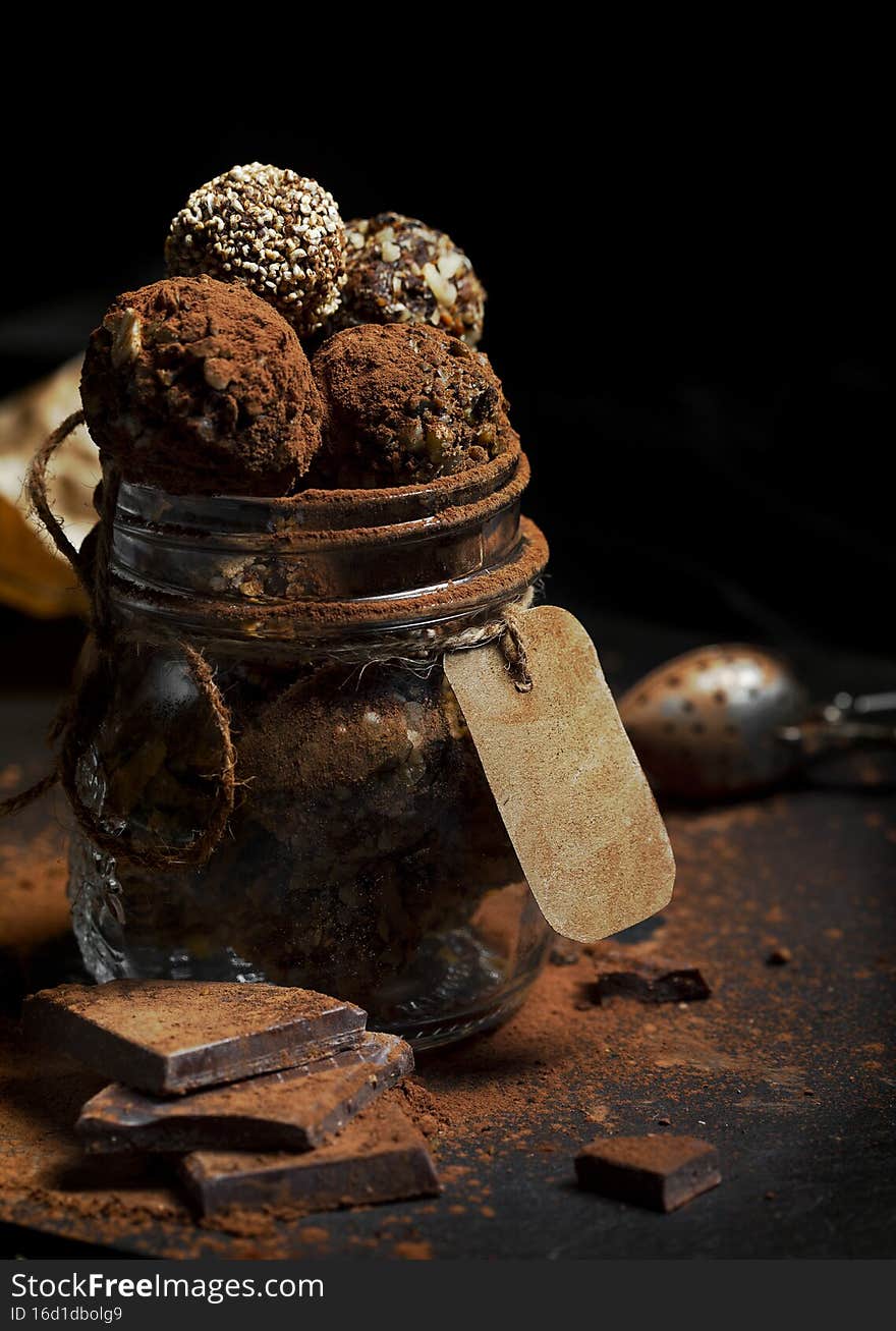 Raw chocolate truffles with sweet potatoes and chopped hazelnuts on a black background. Raw chocolate truffles with sweet potatoes and chopped hazelnuts on a black background