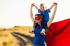 Mom And Son Play Superheroes, Happy Mom Holds A Small Child In Her Arms, Simulate Flight, Pretend To Be Real Superheroes Royalty Free Stock Photo