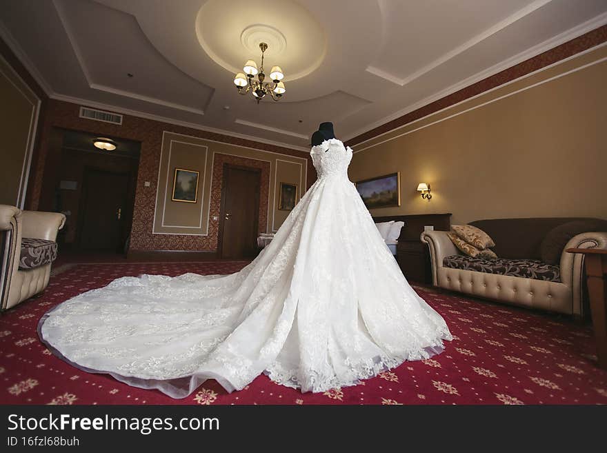 Chic wedding dress and veil on a mannequin in the bride  s gathering room.