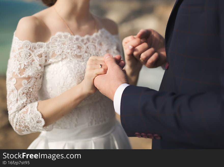 Bride and groom hold hands during the wedding ceremony.