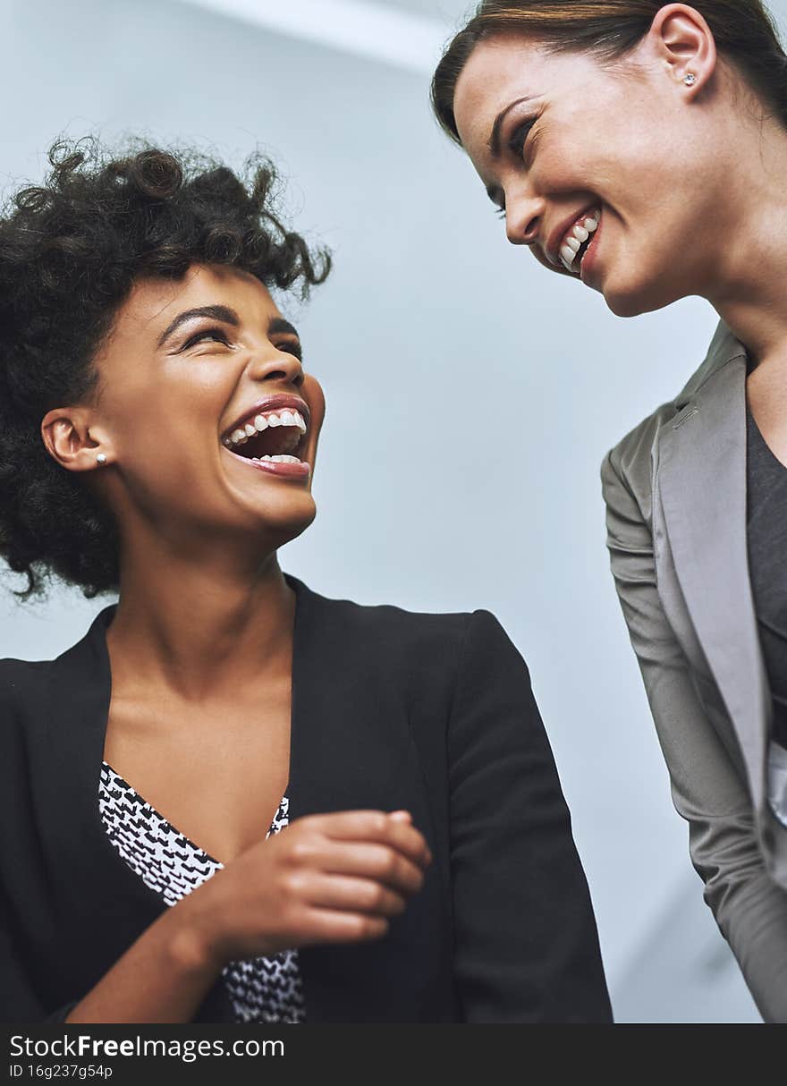 Building positive business relationships. Shot of colleagues laughing together in an office.