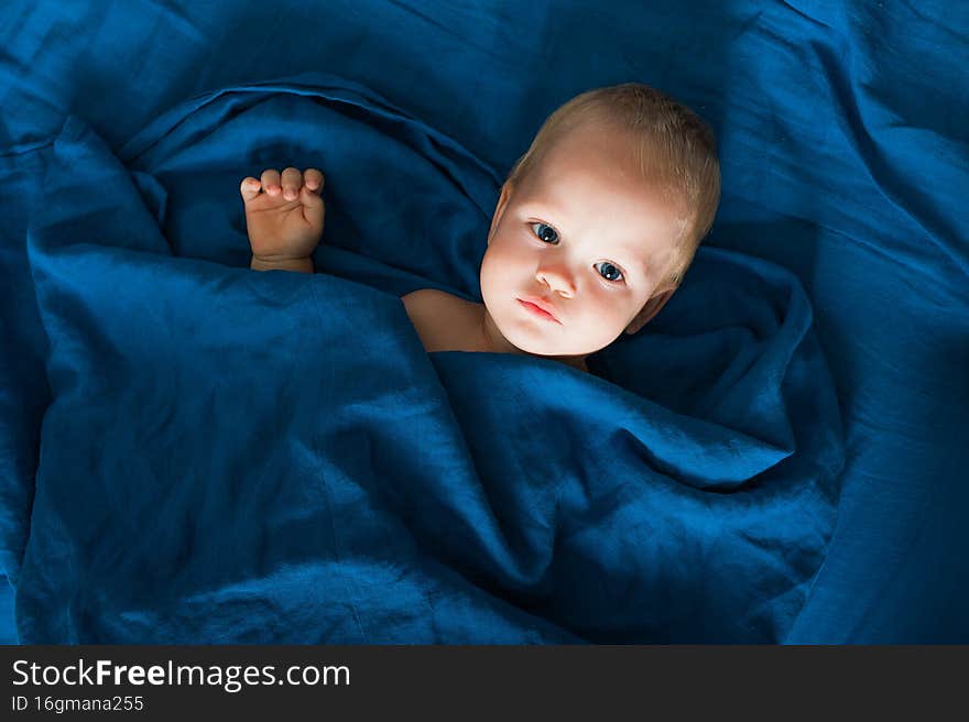 Toddler boy on bed with toy before going to bed. Self-falling asleep infants, children`s night terrors