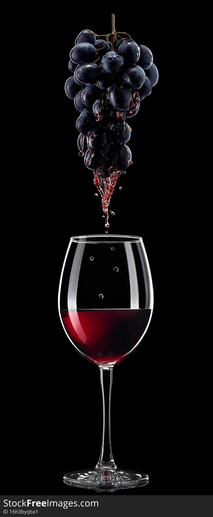 red wine pouring in glass from bunch of grapes isolated on black background