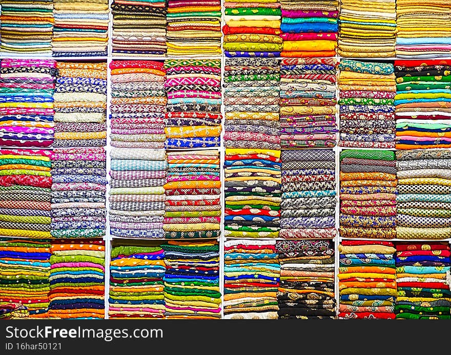 Colored fabrics lie in a pile in an Arab shop, United Arab Emirates