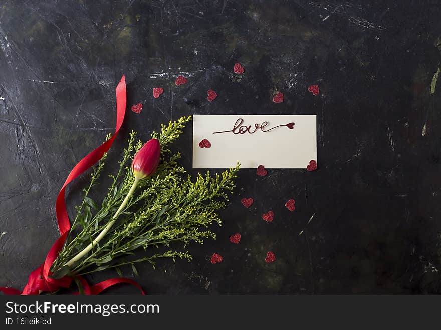 Composition for Valentine`s Day, Women`s Day or birthday. Romantic bouquet of gentle, red tulip on a wooden table close-up