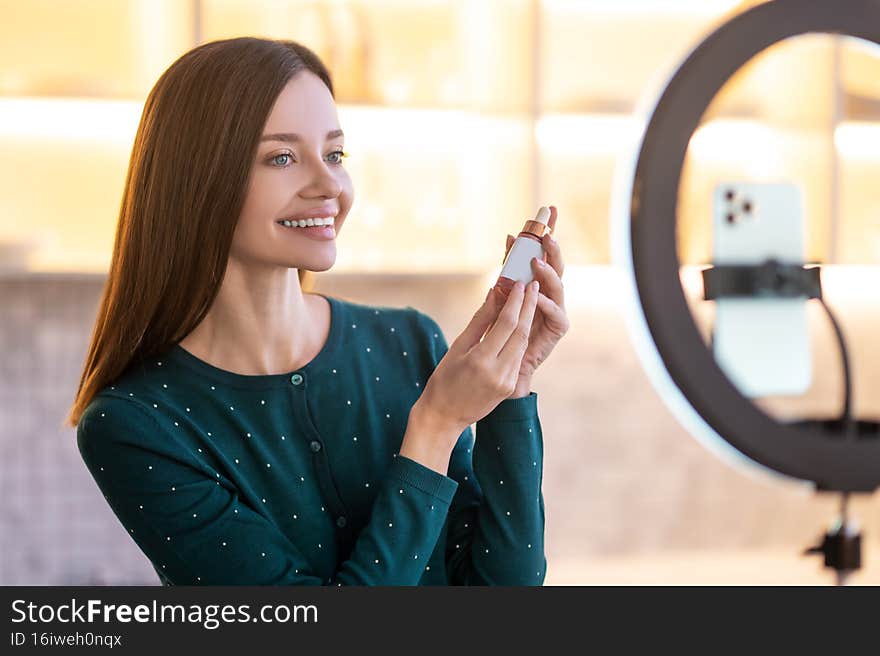 Online presentation. Young woman representing new facial cream and looking involved