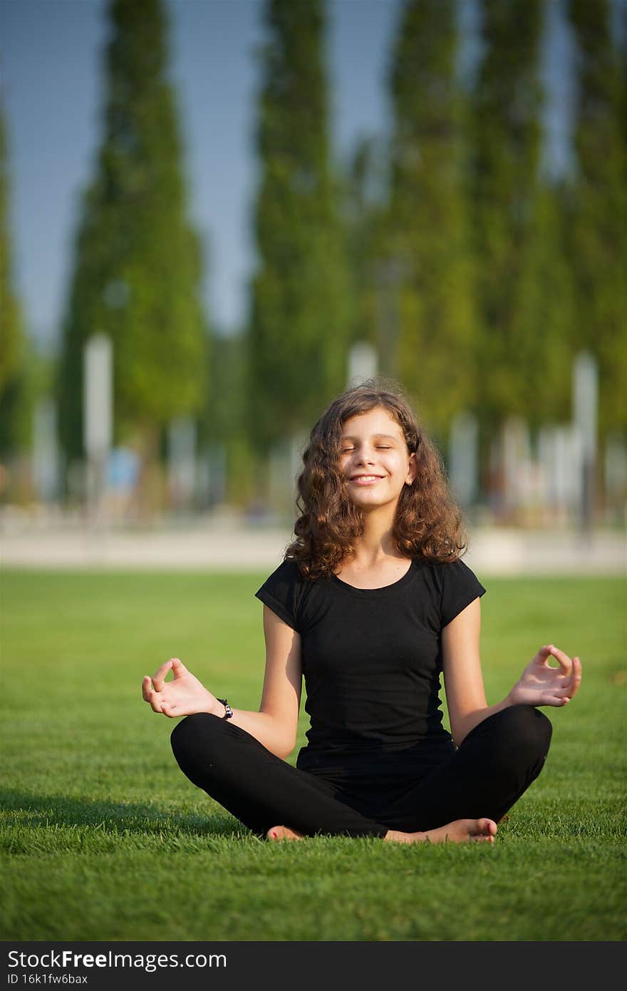 Girl doing yoga school age in sports form shows the elements of sports and asanas