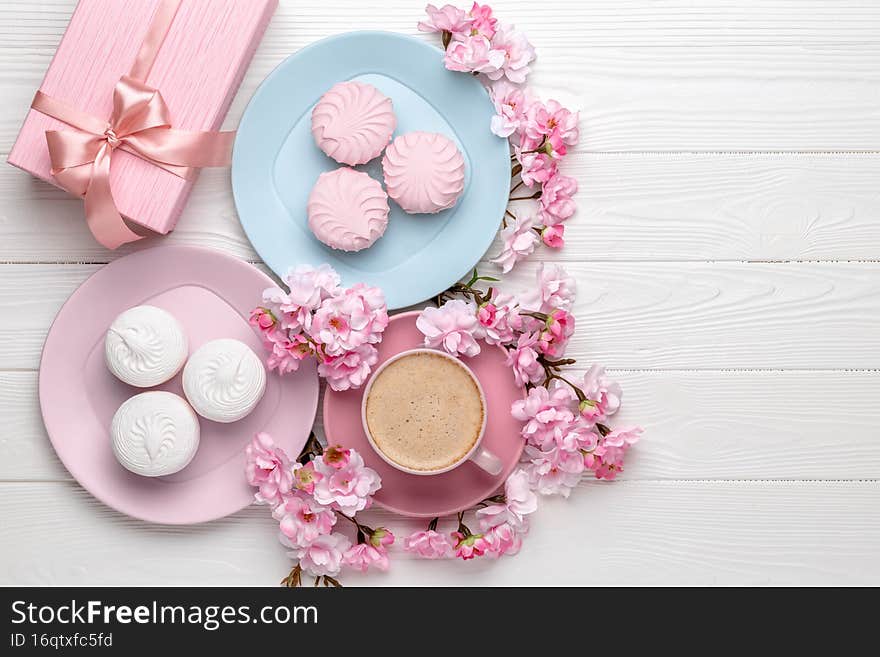 8 March card. Food and drink background. Coffee and dessert on a white wooden table. Spring flowers, cherry blossom, pink bouquet