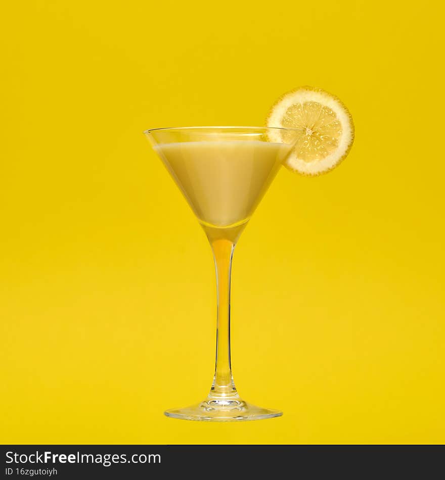 A Banana cocktail in martini glass with a matching yellow background. A Banana cocktail in martini glass with a matching yellow background