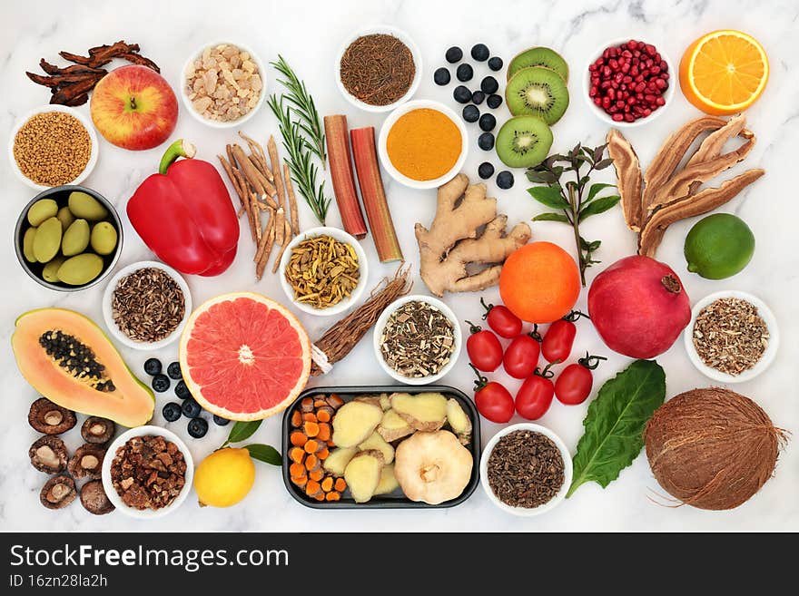 Vegan health food for immune system support with vegetables, fruit, herbs and spice. Foods very high in antioxidants, anthocyanins, protein, fibre, lycopene vitamins, mineral and omega 3. On marble.